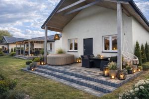 a house with a patio with a fire pit at Bajkowe Domki Marzeń Grei in Węgorzewo