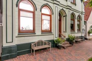 a building with three windows and a bench on a sidewalk at Ferienwohnungen Wiese - Nickel 1 in Arnis