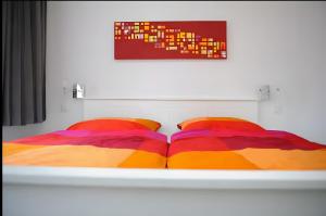 a bed with two colorful pillows on it at Ferienwohnungen Wiese - Nickel 1 in Arnis