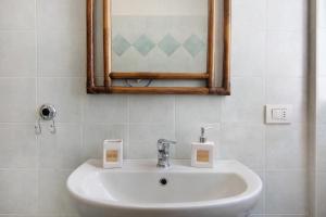 a white sink in a bathroom with a mirror at Colorful Apartment in Colico