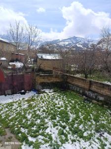 a yard covered in snow with mountains in the background at Qusar Eniğ kend in Qusar