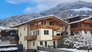 a house in the snow with a mountain in the background at Bergschatz in Wildschönau