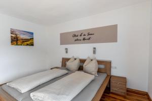 a bedroom with two beds and a sign on the wall at Bergschatz in Wildschönau