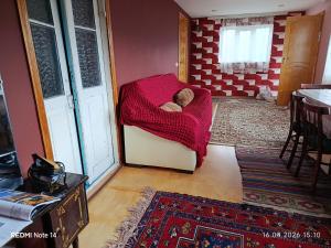 a small room with a teddy bear in a red blanket at Qusar Eniğ kend in Qusar