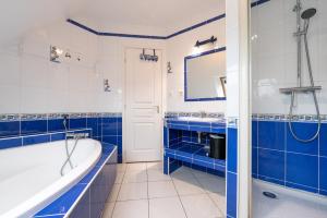 a blue and white bathroom with a tub and sink at Maison Ker Galeret in Sarzeau +15 photos