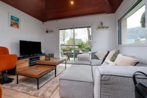 a living room with a couch and a tv at Maison Ker Galeret in Sarzeau