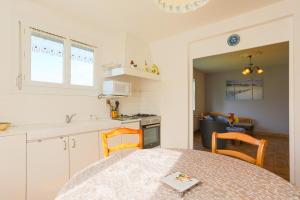 a kitchen with a table and chairs and a kitchen with a sink at Maison Plouha proche plage in Plouha +12 photos