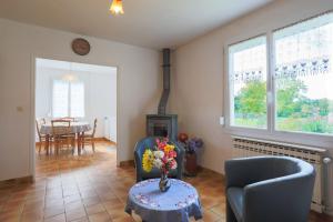 a living room with two chairs and a table with a vase of flowers at Maison Plouha proche plage in Plouha