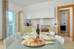 a dining room with a table with a bottle of wine at Villa Marconi Apartment 9 in Golfo Aranci