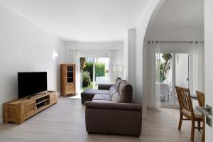 a living room with a couch and a tv at Villa Janeca in Albufeira