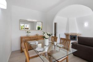 a dining room and living room with a glass table at Villa Janeca in Albufeira