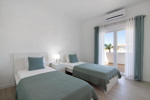 a hotel room with two beds and a balcony at Villa Janeca in Albufeira +23 photos