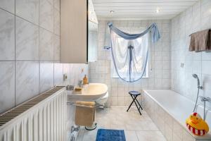 a bathroom with a tub and a sink and a bath tubermottermott at Sandhasen in Lauterbach +16 photos