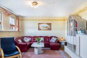 a living room with a red couch and a table at Sandhasen in Lauterbach