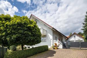 a white house with a black fence at Sandhasen in Lauterbach