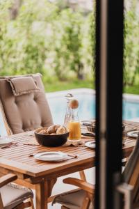 a wooden table with a bowl of food on it at Luxe Villa Maxime in Lazise +6 photos
