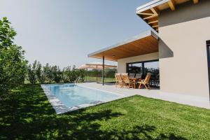 a backyard with a swimming pool and a house at Luxe Villa Maxime in Lazise