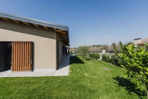 a house with a green yard next to a building at Luxe Villa Maxime in Lazise