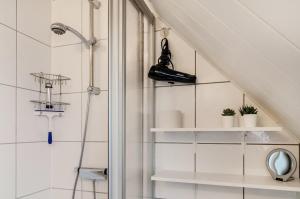 a bathroom with white shelves and a shower at Ferienwohnung Karin in Marienhafe +19 photos