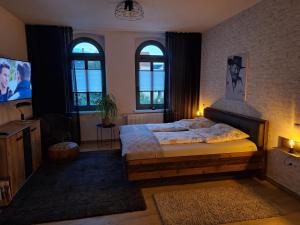 a bedroom with a bed and a sink and windows at Zillestuben Altenburg in Altenburg