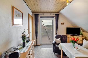 a small living room with a table and a tv at Ferienwohnung Karin in Marienhafe