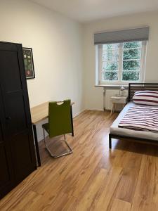 a bedroom with a bed and a desk and a chair at Apartment an der Liitard Kull in Neukirchen-Vluyn