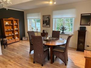 a dining room with a wooden table and chairs at Apartment an der Liitard Kull in Neukirchen-Vluyn +9 photos