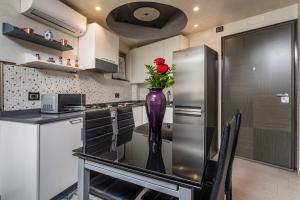 a kitchen with a vase with a red rose in it at Tao Rama Suite in Taormina