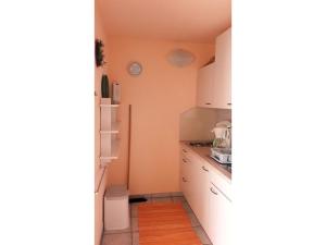 a small kitchen with white cabinets and a refrigerator at Lotte und Helmut Klanner in Daisendorf