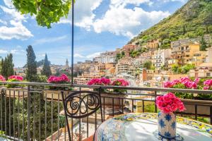 a balcony with a table and a view of a city at Tao Rama Suite in Taormina