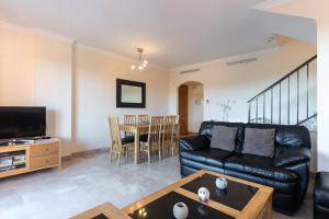 a living room with a black leather couch and a table at Duplex apartment Estepona in Estepona