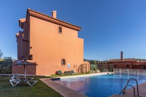 a villa with a swimming pool next to a building at Duplex apartment Estepona in Estepona