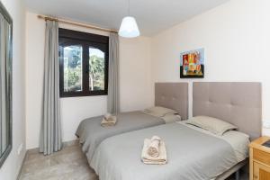 two beds in a room with a window at Duplex apartment Estepona in Estepona +21 photos