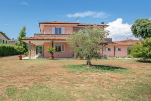 a house with a tree in a yard at Villa Angela in Capannori