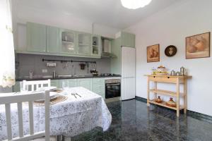 a kitchen with green cabinets and a table with a white table cloth at Las Monarcas in Teror