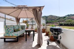 a patio with an umbrella and a table at Las Monarcas in Teror