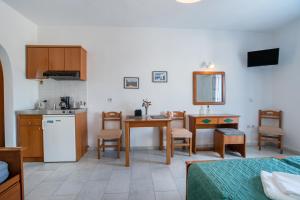 a room with a kitchen and a table with chairs at Galanos Studios Naxos in Naxos Chora