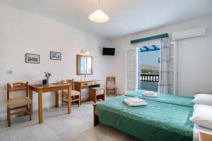 a bedroom with a bed and a desk and a table at Galanos Studios Naxos in Naxos Chora