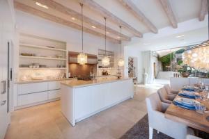 a kitchen with white cabinets and a table with chairs at Villa Oasis Del Mar in El Toro