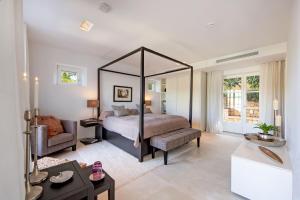 a bedroom with a large canopy bed and a living room at Villa Oasis Del Mar in El Toro +37 photos