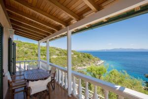 a balcony with a table and chairs looking out at the ocean at Dolphin villa 3 in Gaios