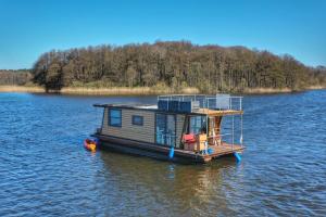 a small house boat floating on a lake at Gemütliches Hausboot Seeliebe Woma in Fürstenberg