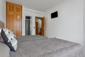 a bedroom with two beds and a television on the wall at Corralejo Ian’s Dreams in Corralejo