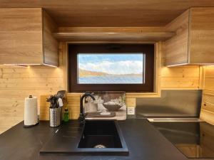 a kitchen with a sink and a window in a kitchen at Gemütliches Hausboot Seeliebe Woma in Fürstenberg