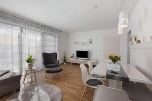 a white living room with a table and chairs at bleib. Boutique Premium Lake House in Allensbach