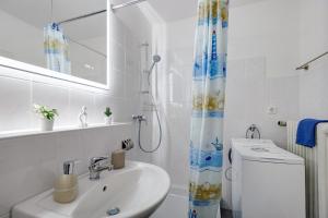 a bathroom with a sink and a shower curtain at bleib. Boutique Premium Lake House in Allensbach +23 photos