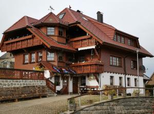 a large wooden house with a red roof at Ferienwohnung Steinbühlschlössle in Schönwald