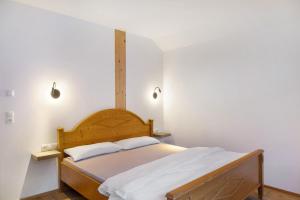 a bedroom with a wooden bed with two white pillows at Apartement Ben´s Auszeit Top 4 in Umhausen