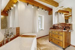 a bathroom with a tub and a sink and a mirror at Ferienhaus im Vorwerk Nickern in Dresden +19 photos