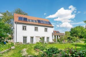 a white house with solar panels on the roof at Ferienhaus im Vorwerk Nickern in Dresden